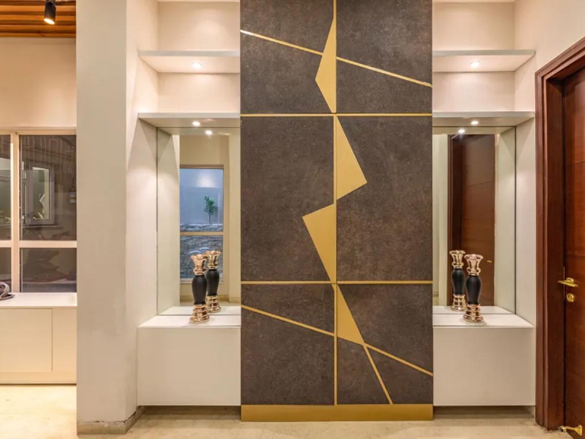Modern Foyer Design With Dark Accent Wall And Gold Panelling